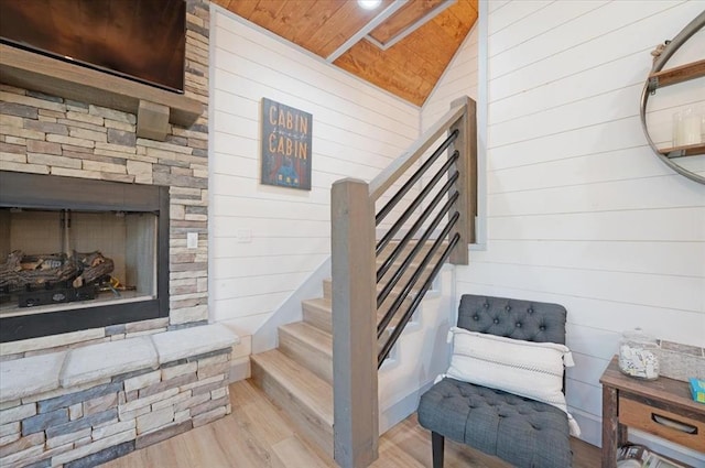 203 Secluded Cir, Broken Bow, OK 74728 - stairs with wooden walls, wood finished floors, vaulted ceiling, wooden ceiling, and a stone fireplace