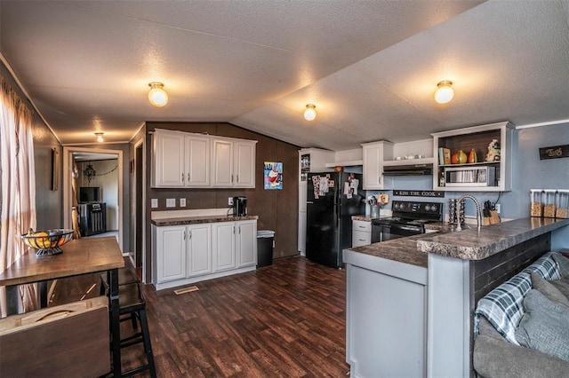 kitchen featuring dark wood-type flooring, dark countertops, a peninsula, and black appliances