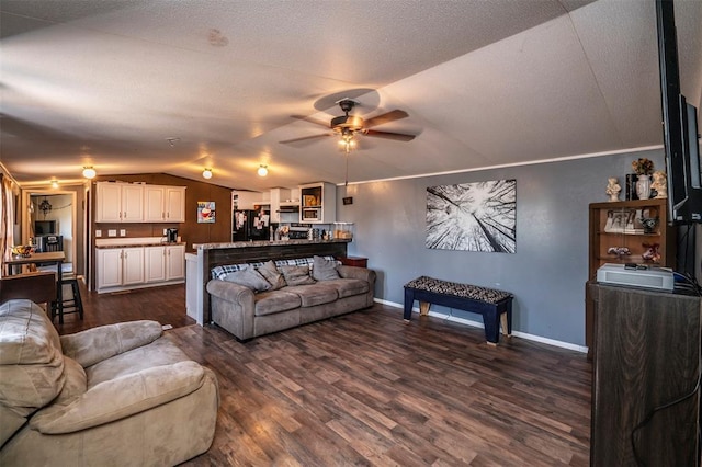 living room with lofted ceiling, a ceiling fan, dark wood-type flooring, and baseboards