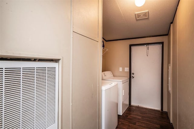 washroom featuring a heating unit, washing machine and dryer, dark wood finished floors, visible vents, and laundry area