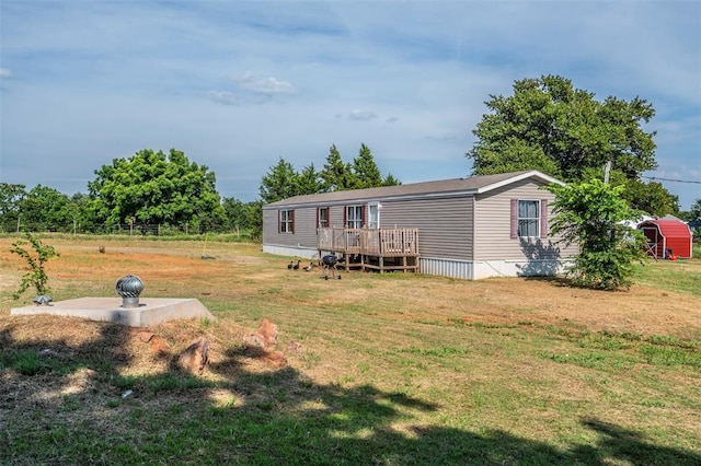 back of house featuring a lawn and a deck