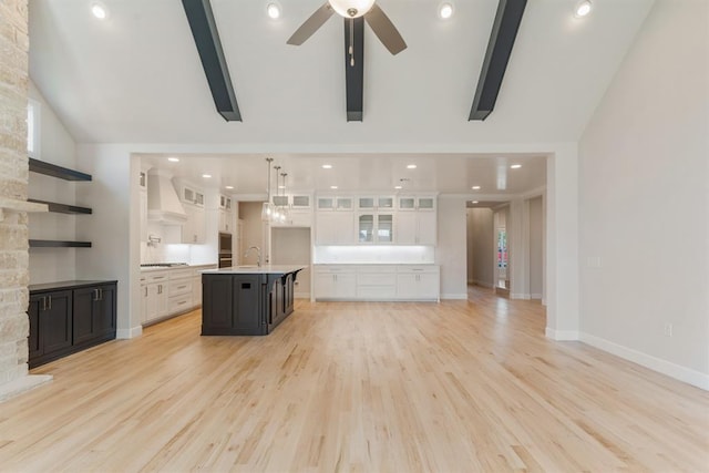 15632 Flora Ave, Edmond, OK 73013 - unfurnished living room featuring a sink, a ceiling fan, light wood-style flooring, baseboards, and high vaulted ceiling