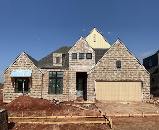 15633 Stillmeadows Dr, Edmond, OK 73013 - view of front of property with board and batten siding, brick siding, an attached garage, driveway, and a shingled roof