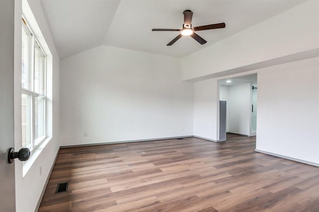 unfurnished room with baseboards, visible vents, lofted ceiling, wood finished floors, and ceiling fan