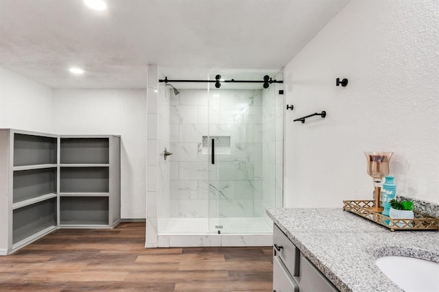 full bathroom with vanity, wood finished floors, and a marble finish shower