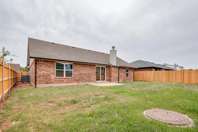 back of house with a chimney, a fenced backyard, cooling unit, a patio, and brick siding