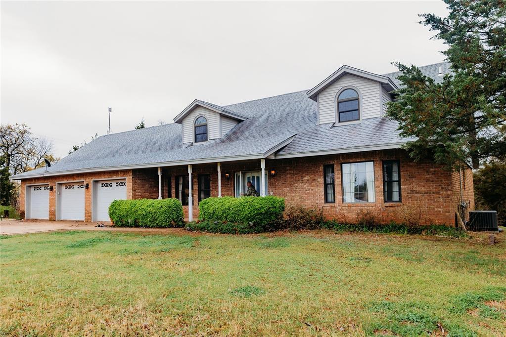 870805 S 3416th Rd, Chandler, OK 74834 - view of front facade with a garage, a front yard, and brick siding
