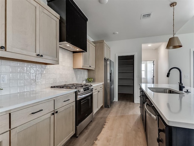 12909 NW 143rd St, Piedmont, OK 73078 - kitchen with stainless steel appliances, a sink, light countertops, light wood finished floors, and tasteful backsplash