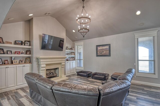 393 Haloka Ave, Washington, OK 73093 - living area featuring vaulted ceiling, a fireplace with raised hearth, visible vents, a notable chandelier, and wood finished floors