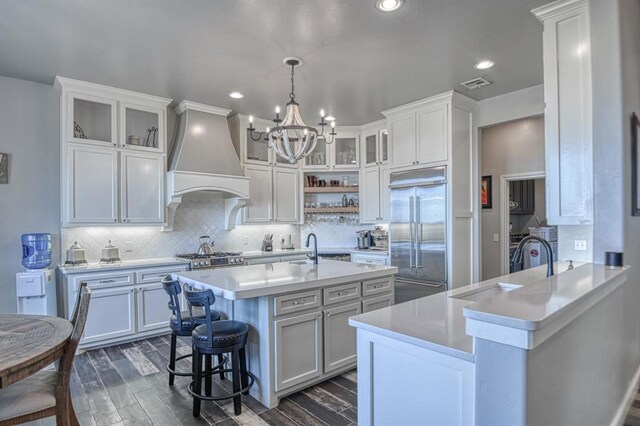393 Haloka Ave, Washington, OK 73093 - kitchen with light countertops, visible vents, custom range hood, a breakfast bar area, and stainless steel built in fridge