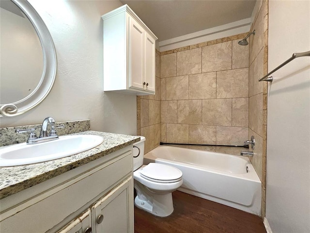 bathroom featuring toilet, vanity, shower / washtub combination, and wood finished floors
