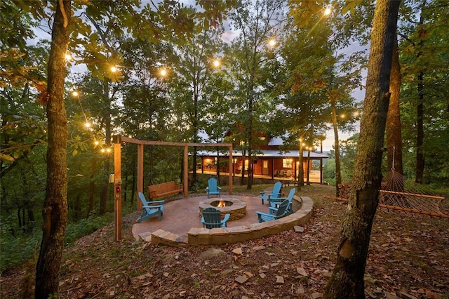 357 Little Creek Ln, Broken Bow, OK 74728 - yard at dusk with a fire pit and a patio area