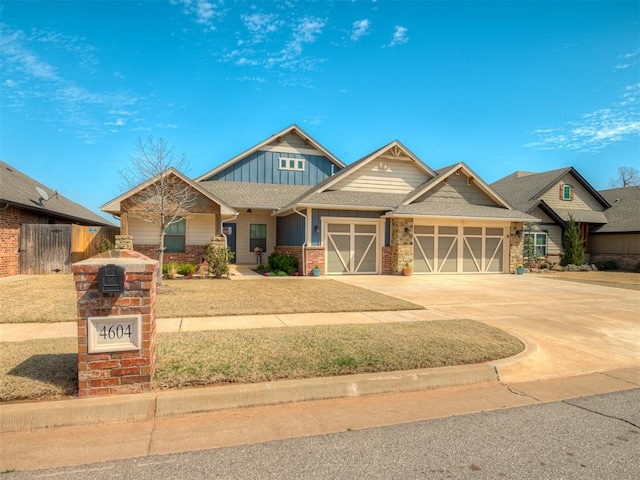 craftsman house with an attached garage, concrete driveway, roof with shingles, and board and batten siding