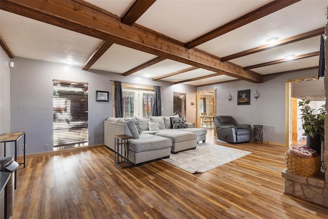 living room featuring baseboards, beamed ceiling, and wood finished floors