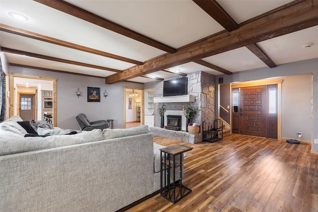 living room featuring a stone fireplace, a wealth of natural light, beam ceiling, and wood-type flooring