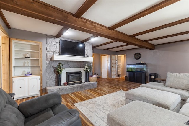 living room with a fireplace, wood finished floors, and beam ceiling