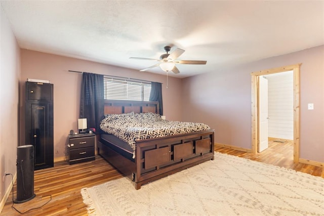 bedroom featuring baseboards, wood finished floors, and ceiling fan