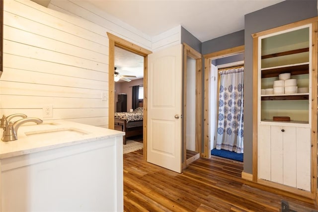 laundry room featuring a sink, dark wood-type flooring, and ceiling fan