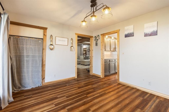 empty room with baseboards and dark wood-style flooring
