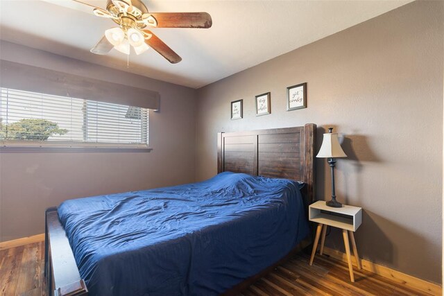 bedroom featuring baseboards, wood finished floors, and a ceiling fan