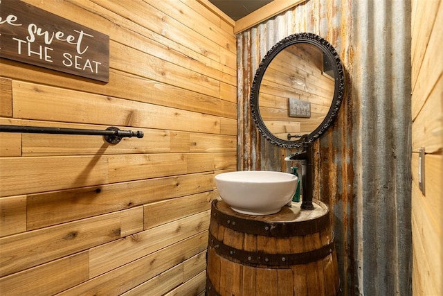 bathroom featuring a sink and wood walls