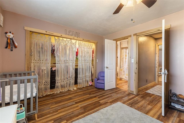 bedroom featuring a closet, baseboards, ceiling fan, and wood finished floors