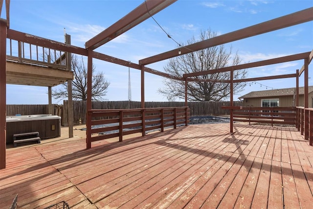 wooden deck with a hot tub and a fenced backyard