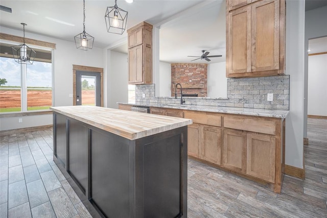 1430 County St Unit 2977, Blanchard, OK 73010 - kitchen with butcher block counters, a ceiling fan, decorative backsplash, a center island, and light wood finished floors