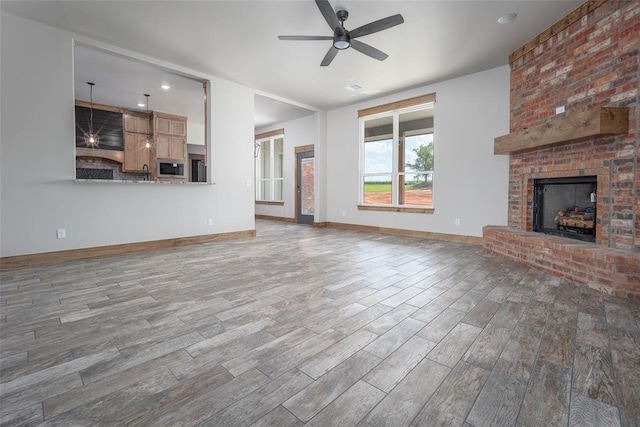 1430 County St Unit 2977, Blanchard, OK 73010 - unfurnished living room with ceiling fan, a brick fireplace, and wood finished floors