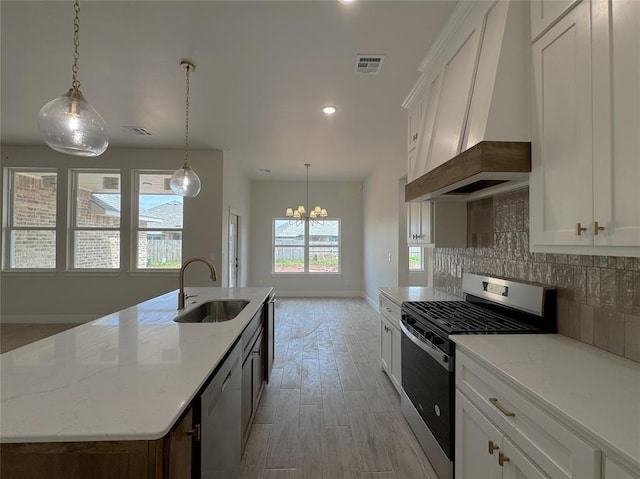 2420 Northfork Dr, Moore, OK 73160 - kitchen with appliances with stainless steel finishes, a sink, premium range hood, baseboards, and a kitchen island with sink