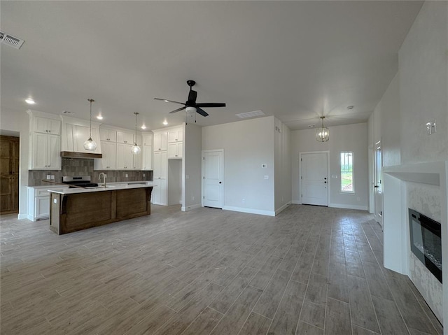 2420 Northfork Dr, Moore, OK 73160 - kitchen with open floor plan, light countertops, white cabinetry, backsplash, and recessed lighting