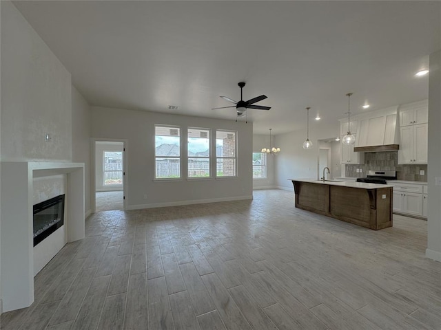 2420 Northfork Dr, Moore, OK 73160 - kitchen featuring gas range, custom range hood, open floor plan, light wood-type flooring, and light countertops