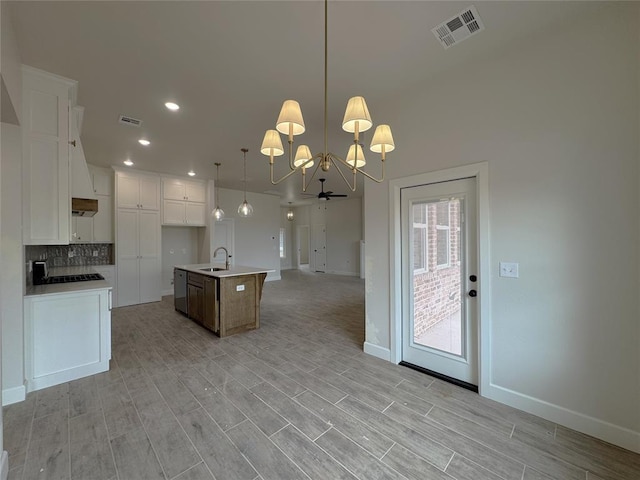 2420 Northfork Dr, Moore, OK 73160 - kitchen featuring a sink, open floor plan, a chandelier, baseboards, and white cabinetry