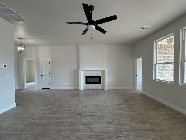 2420 Northfork Dr, Moore, OK 73160 - unfurnished living room with a fireplace, ceiling fan, a chandelier, baseboards, and wood finished floors