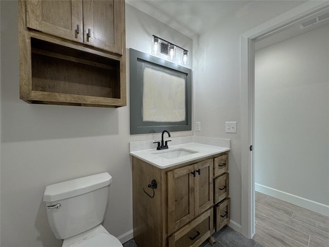 2420 Northfork Dr, Moore, OK 73160 - bathroom with toilet, vanity, baseboards, and wood finished floors