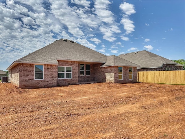 2420 Northfork Dr, Moore, OK 73160 - rear view of property featuring fence, roof with shingles, brick siding, and central air condition unit