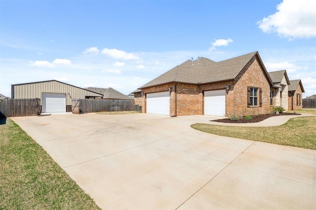 view of side of home featuring driveway, brick siding, fence, and an attached garage
