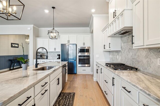kitchen with a notable chandelier, a sink, stainless steel appliances, and custom exhaust hood