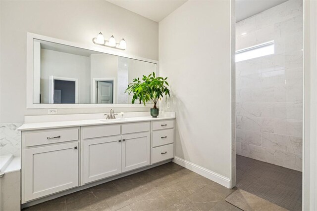 bathroom featuring vanity, baseboards, and a walk in shower