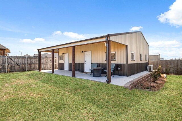 back of property with a fenced backyard, a patio, central AC unit, and a yard