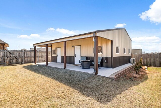 exterior space with a fenced backyard, a lawn, central AC, and a patio