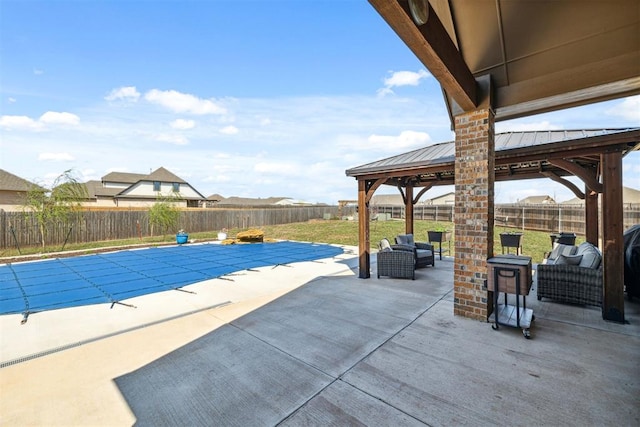 view of swimming pool with a fenced backyard, a fenced in pool, a gazebo, and an outdoor living space