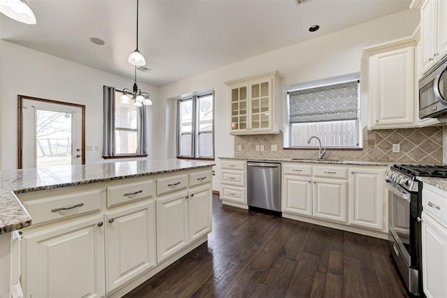 kitchen featuring dark wood-type flooring, a sink, stainless steel appliances, and backsplash