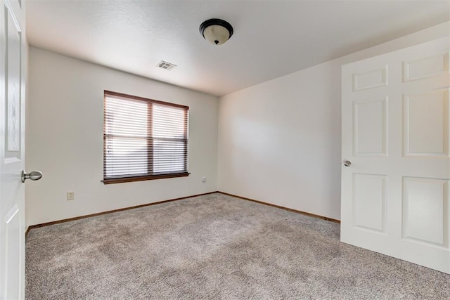 unfurnished room featuring carpet, baseboards, and visible vents