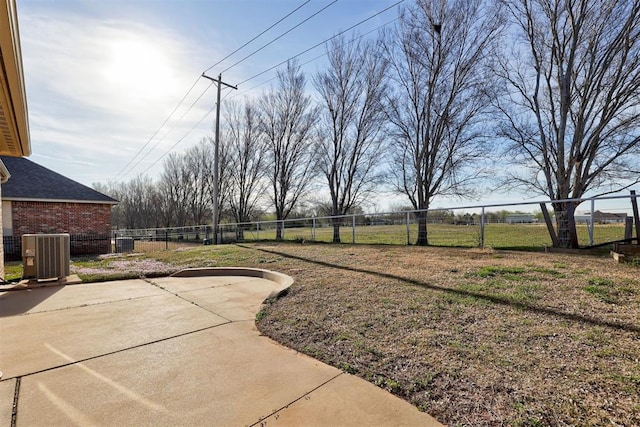 view of yard with fence, central AC, and a patio area