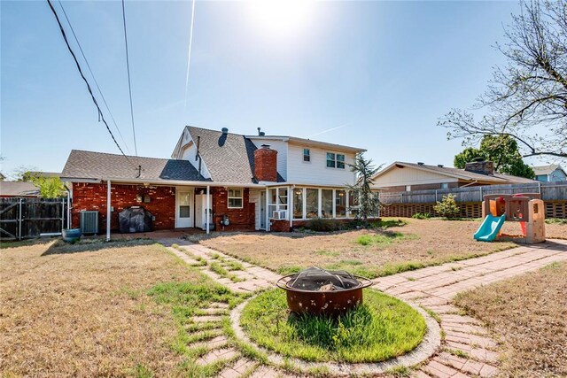7205 N Seminole Ter, Warr Acres, OK 73132 - back of house featuring a fire pit, a fenced backyard, central air condition unit, and a playground