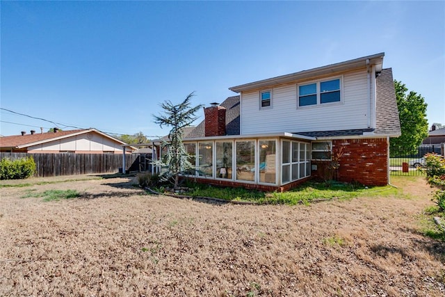 7205 N Seminole Ter, Warr Acres, OK 73132 - back of property featuring brick siding, a fenced backyard, a sunroom, and a chimney