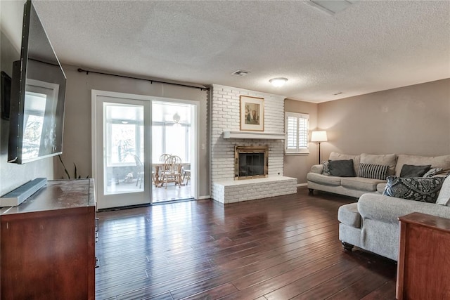 7205 N Seminole Ter, Warr Acres, OK 73132 - living room with dark wood-style flooring, visible vents, a textured ceiling, and a fireplace