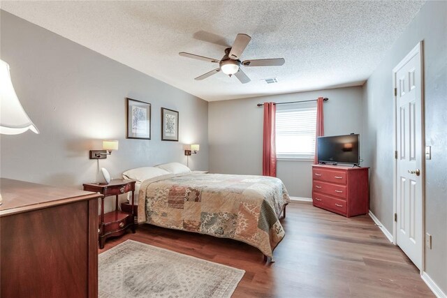 7205 N Seminole Ter, Warr Acres, OK 73132 - bedroom featuring visible vents, a ceiling fan, wood finished floors, and a textured ceiling