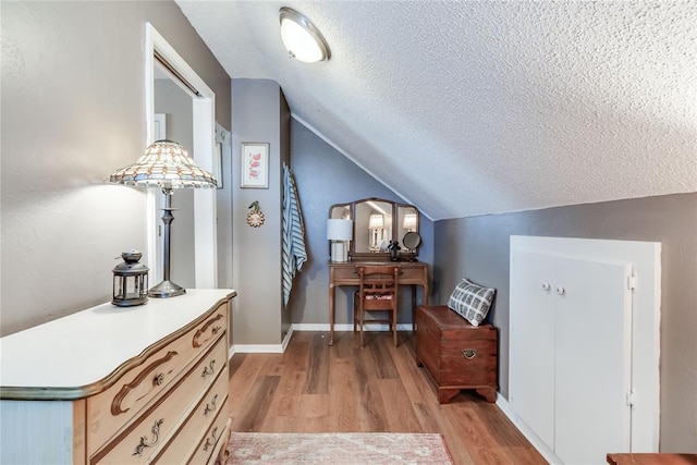 7205 N Seminole Ter, Warr Acres, OK 73132 - interior space featuring light wood-style floors, baseboards, lofted ceiling, and a textured ceiling